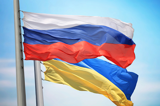 Flag of Russia and Ukraine against the background of the blue sky